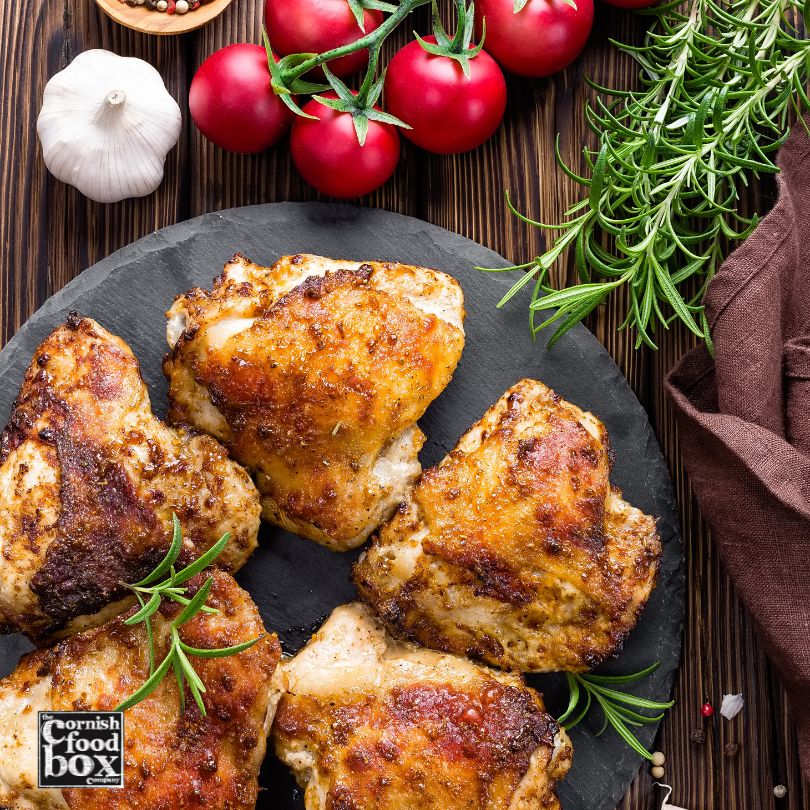 cooked chicken thighs on a slate plate