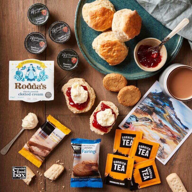 Cornish Cream Tea Gift Set featuring freshly baked scones, Rodda’s Cornish clotted cream, Boddington’s strawberry jam, Cornish tea bags, and shortbread biscuits, elegantly presented in a gift box.